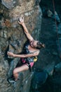 Young slender climber climbs a rock Royalty Free Stock Photo