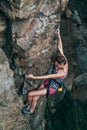 Young slender climber climbs a rock Royalty Free Stock Photo