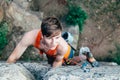 Young slender climber climbs a rock Royalty Free Stock Photo