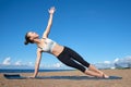 Young slender girl doing yoga on the beach on a sunny morning, plank exercise, healthy lifestyle Royalty Free Stock Photo