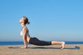 Young slender girl doing yoga on the beach on a sunny morning, plank exercise, healthy lifestyle Royalty Free Stock Photo