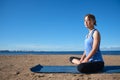 Young slender girl doing yoga on the beach on a sunny morning, sad mood, sad thoughts Royalty Free Stock Photo