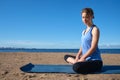 Young slender girl doing yoga on the beach on a sunny morning, sad mood, sad thoughts Royalty Free Stock Photo