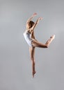 A young slender girl gymnast jumps high in the dance.