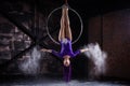 A young, slender girl in a lavender leotard and lilac dreads, doing gymnastics on the air ring, the Hoop and throws the Royalty Free Stock Photo