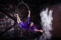 A young, slender girl in a lavender leotard and lilac dreads, doing gymnastics on the air ring, the Hoop and throws the Royalty Free Stock Photo