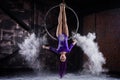 A young, slender girl in a lavender leotard and lilac dreads, doing gymnastics on the air ring, the Hoop and throws the Royalty Free Stock Photo