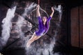A young, slender girl in a lavender leotard and lilac dreads, doing gymnastics on the air ring, the Hoop and throws the Royalty Free Stock Photo
