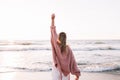 A young slender girl stands alone on the beach or ocean and look at the horizont. A woman dressed in a warm sweater Royalty Free Stock Photo