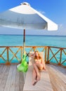 The young slender woman the blonde sunbathing lies on a chaise lounge against the tropical ocean Royalty Free Stock Photo