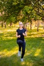 Young, slender woman doing jogging on the spot. Sports activities in the summer park Royalty Free Stock Photo