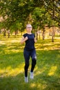 Young, slender woman doing jogging on the spot. Sports activities in the summer park Royalty Free Stock Photo