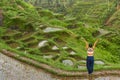 A young slender woman stands on rice terraces on the popular tourist island of Bali