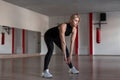 Young slim athletic woman in sporty black fashionable clothes on a training in the gym. Attractive girl makes the exercises