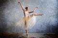 Young ballerina in a golden colored dancing costume is posing in a loft studio Royalty Free Stock Photo