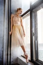 Young ballerina in a golden colored dancing costume is posing in a loft studio Royalty Free Stock Photo