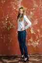 Young slim beautiful young blond woman with long legs and hair in Bedlam shirt and jeans Royalty Free Stock Photo