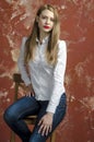 Young slim beautiful young blond woman with long legs and hair in Bedlam shirt and jeans Royalty Free Stock Photo