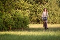 Young, slim, blonde woman on bicycle against defocused park landscape. Autumn color shade Royalty Free Stock Photo