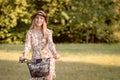 Young, slim, blonde woman on bicycle against defocused park landscape. Autumn color shade Royalty Free Stock Photo