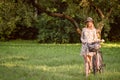 Young, slim, blonde woman on bicycle against defocused park landscape. Autumn color shade Royalty Free Stock Photo