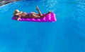 Young slim brunette woman in straw hat gets suntan on air mattress swimming pool Royalty Free Stock Photo