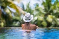 Young slim brunette woman sunbathe in tropical swimming pool Royalty Free Stock Photo