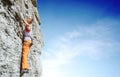 Young slim female rock climber climbing on the cliff Royalty Free Stock Photo