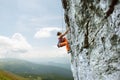 Young slim female rock climber climbing on the cliff Royalty Free Stock Photo
