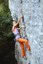 Young slim female rock climber climbing on the cliff Royalty Free Stock Photo