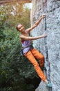 Young slim female rock climber climbing on the cliff Royalty Free Stock Photo