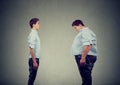 Young slim fit man looking at fat himself. Diet choice right nutrition healthy lifestyle Royalty Free Stock Photo