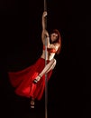 Young Redhead Athletic Pole Dance Girl In A Red Dress On A Black Studio Background