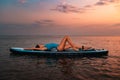 A young slim tanned woman in swimsuit lies on a sup board. Sunset in the background. Copy space. Concept of summer water Royalty Free Stock Photo