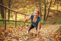 Young slim woman doing fitness exercise stretching in autumn forest park, sport and healthy lifestyle Royalty Free Stock Photo