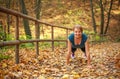 Young slim woman doing fitness exercise stretching in autumn forest park, sport and healthy lifestyle Royalty Free Stock Photo