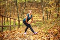 Young slim woman doing fitness exercise stretching in autumn forest park, sport and healthy lifestyle Royalty Free Stock Photo