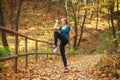 Young slim woman doing fitness exercise stretching in autumn forest park, sport and healthy lifestyle Royalty Free Stock Photo