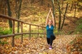 Young slim woman doing fitness exercise stretching in autumn forest park, sport and healthy lifestyle Royalty Free Stock Photo