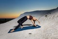 Young slim woman doing wild thing yoga pose on the mat outdoors at sunset Royalty Free Stock Photo