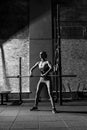 Young slim woman exercising with a long metal bar