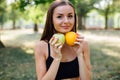 Young slim woman having snack after working out outdoors in the park. Sitting on the grass, eating juicy apple on fresh air Royalty Free Stock Photo