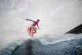 Young slim woman jumping up the blue wave against the grey sky Royalty Free Stock Photo