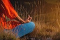 Young slim woman in a lotus position in nature in the mountains, close-up sitting in the grass at sunset, meditating Royalty Free Stock Photo