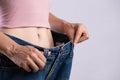 Young slim woman in oversized blue jeans. Fit woman wearing too large pants. Healthcare and woman diet lifestyle concept to reduce Royalty Free Stock Photo