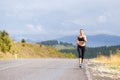 Young slim woman in sportswear jogging on the road Royalty Free Stock Photo