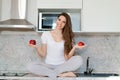 Young slim woman standing in kitchen on table, holding red apples, looking Royalty Free Stock Photo