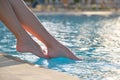 Young slim woman& x27;s legs relaxing near swimming pool in summer sun. Tropical vacation concept Royalty Free Stock Photo