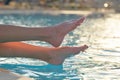 Young slim woman& x27;s legs relaxing near swimming pool in summer sun. Tropical vacation concept Royalty Free Stock Photo