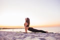 Young slim yogi woman doing Urdhva Mukha Svanasana or Upward Facing Dog Pose against sunset on the beach. Healhy lifestyle concept Royalty Free Stock Photo